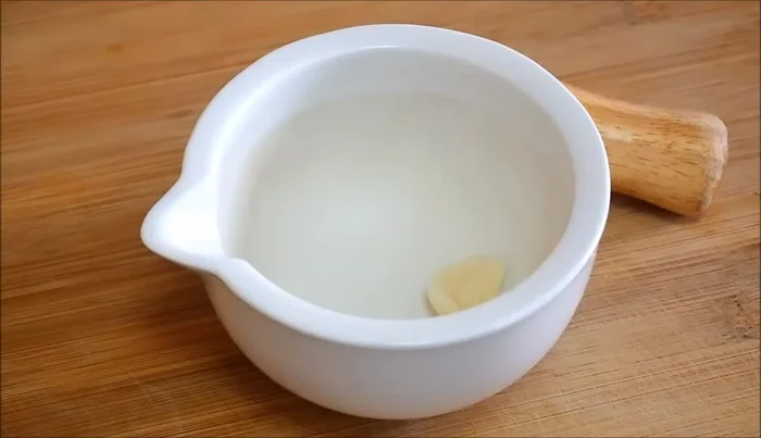 Mientras tanto, en un mortero, machacar un diente de ajo, sal y perejil fresco.