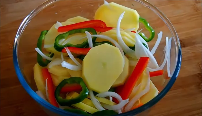 Cortar los pimientos y la cebolla en juliana. Pelar y cortar las patatas en rodajas de 1 cm aproximadamente.
