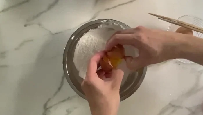 Preparar la mezcla para rebozar: batir un huevo con almidón de maíz hasta obtener una consistencia líquida. [101.829]