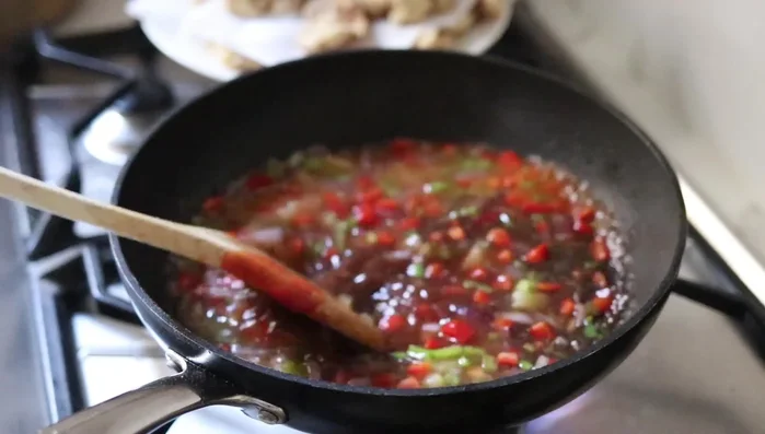 Añadir vinagre, salsa de soja, azúcar y un poco de agua a la sartén con las verduras. Cocinar hasta que la salsa espese. [225.96]