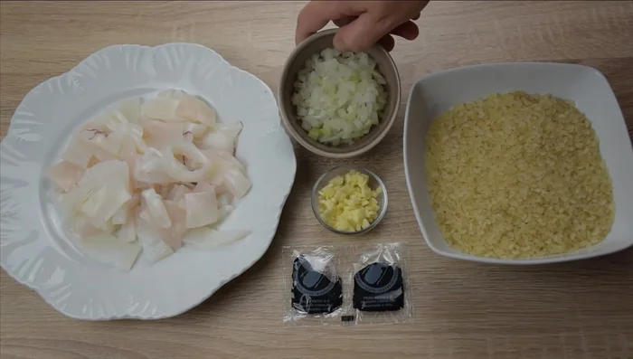 Mientras tanto, preparar los ingredientes del arroz: Cortar los calamares, media cebolla y los ajos. Reservar la tinta de calamar. (143.53)