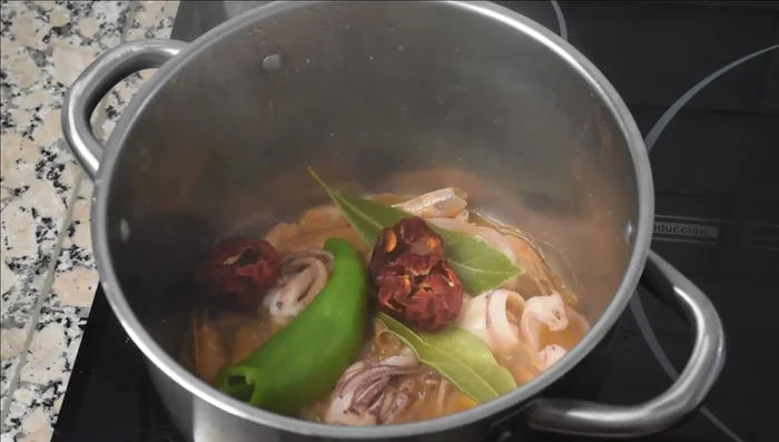 Añadir el tomate, pimiento verde, laurel, cebolletas y agua. Llevar a ebullición, retirar la espuma y cocinar a fuego medio durante 35-40 minutos sin tapar. Colar el caldo. (83.86)