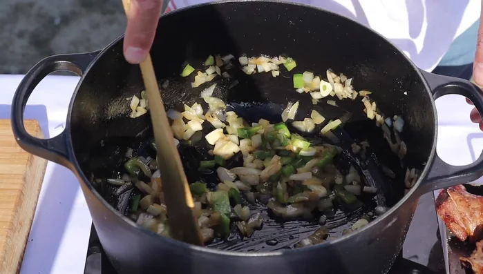 Incorpore el ajo y, una vez sofrito, añada la pulpa de los pimientos choriceros (o pimentón) y el tomate rallado.