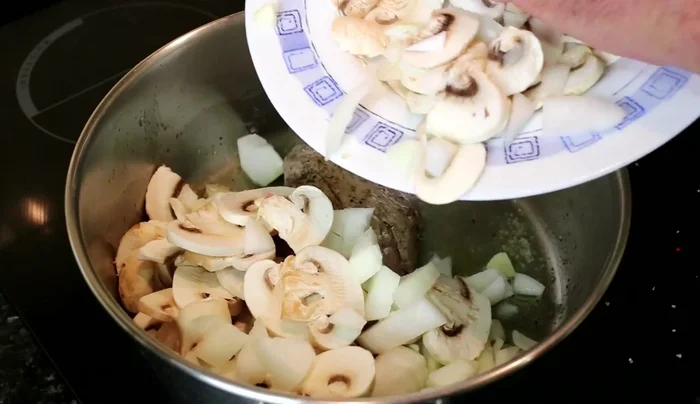 Añadir los champiñones, la cebolla y el ajo a la cacerola. Tapar y cocinar hasta que las verduras estén tiernas (aproximadamente 15 minutos).