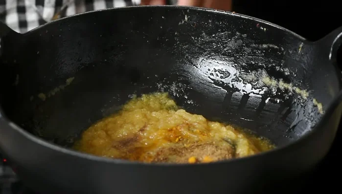 Incorporar las especias en polvo (comino, cilantro, cúrcuma, chile), un poco de agua y sofreír hasta que el aceite se separe de las especias.