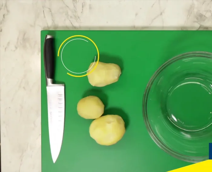 Lavar las patatas, pelarlas, cortarlas y colocarlas en un bol de cristal. Picar el cebollino y las cebolletas y añadirlas a las patatas.