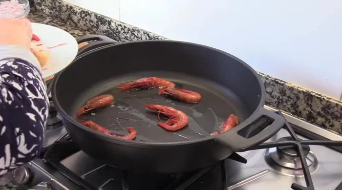 Sofreír las gambas en una cazuela con un poco de aceite de oliva caliente. Reservar. (135.51)