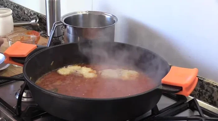 Añadir el rape y las gambas a la cazuela con la salsa de tomate. (299.669)