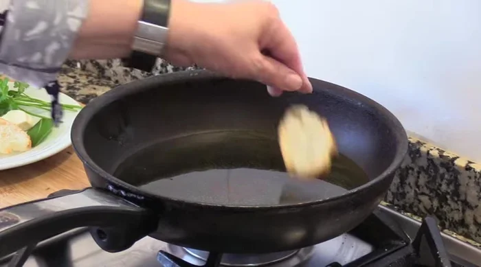 Freír las rebanadas de pan en aceite de oliva caliente. (83.62)