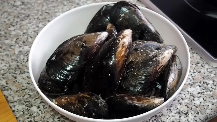 Limpiar bien los mejillones, raspando la concha y quitando las barbillas o restos de algas. Lavar bajo el grifo.