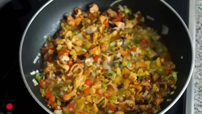Agregar el caldo de los mejillones colado (para evitar restos de concha) y cocinar a fuego fuerte hasta que el sofrito esté seco.