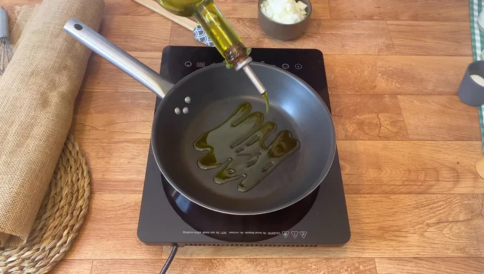 En una sartén, añadir un buen chorro de aceite de oliva. Incorporar la cebolla picada, salpimentar al gusto y pochar a fuego medio durante 4 minutos.