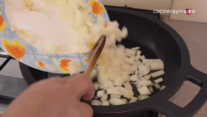 Añadir la cebolla y el ajo picados. Salpimentar y tapar, cocinando a fuego bajo hasta que la cebolla esté casi blanda.
