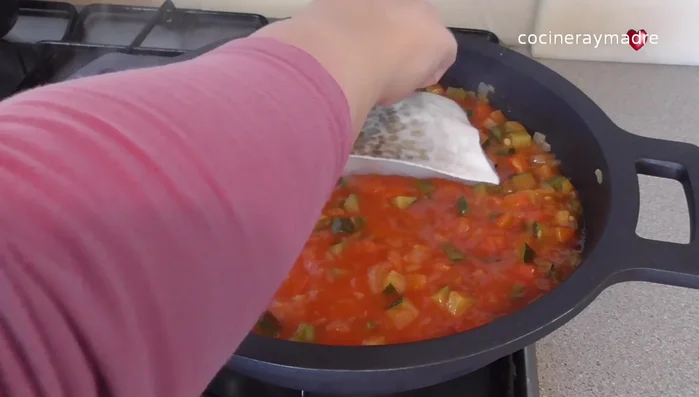 Agregar los filetes de bacalao con la piel hacia arriba. Salpimentar ligeramente y tapar. Cocinar durante 5 minutos.