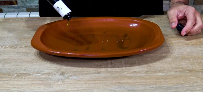Colocar el besugo en una fuente de barro con un chorro de aceite de oliva virgen extra, sal y pimienta.