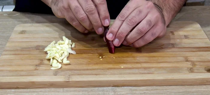 Picar la guindilla (quitar las semillas si se desea menos picante).