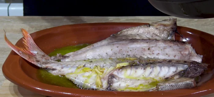 Sacar el besugo del horno, añadir la salsa por encima y espolvorear con perejil fresco.