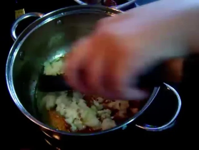 Retirar la carne y añadir la cebolla a la olla. Sofreír con un poco de sal hasta que esté dorada. Agregar el ajo.