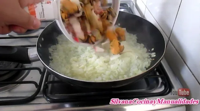 Incorporar los mariscos cocidos (ya cocidos), comino, ají de color (o pimentón, paprika). Revolver y cocinar por 5 minutos más.