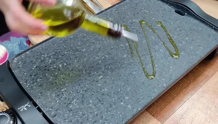 Calentar la plancha a fuego fuerte y agregar un chorrito de aceite de oliva.