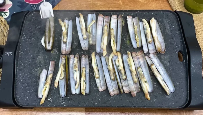 Dar la vuelta a las navajas. Agregar sal y una cucharada del aliño a cada una.