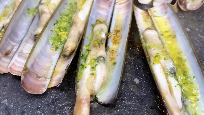 Cocinar hasta que las navajas empiecen a burbujear (aproximadamente 2 minutos y medio más).