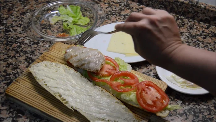 Colocar el lomo de cerdo, el queso (si no se fundió previamente), el bacon y finalmente el huevo partido por la mitad.