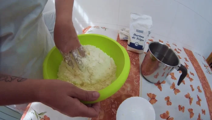 Añadir gradualmente el agua, mezclando constantemente hasta obtener una masa homogénea y pastosa. No agregar toda el agua de golpe.