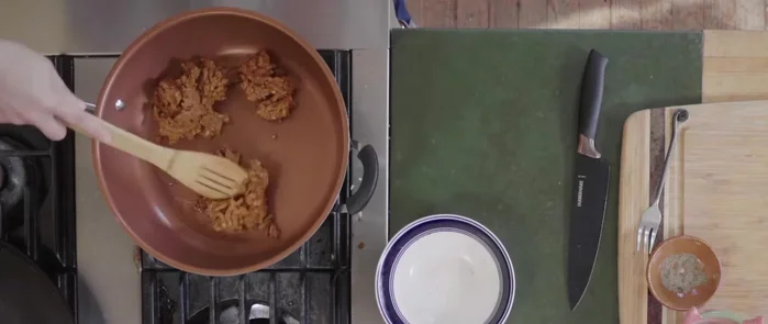 Añadir el chorizo a la sartén y desmenuzarlo con el dorso de una cuchara. Cocinar hasta que esté desmenuzado.