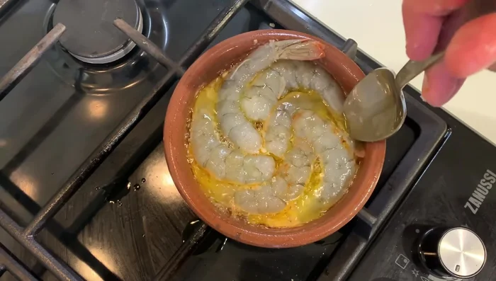 Agregar las gambas a la olla. Cocinar por un lado durante 3 minutos.