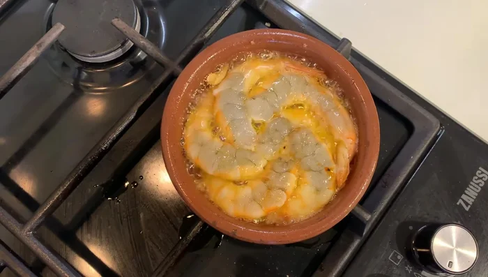 Dar la vuelta a las gambas. Sazonar con sal y pimienta.