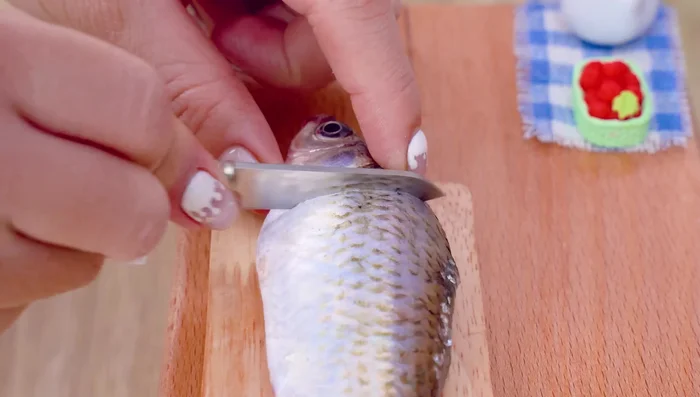 Limpiar y preparar el pescado. Quitar la cabeza y hacer cortes en el cuerpo.