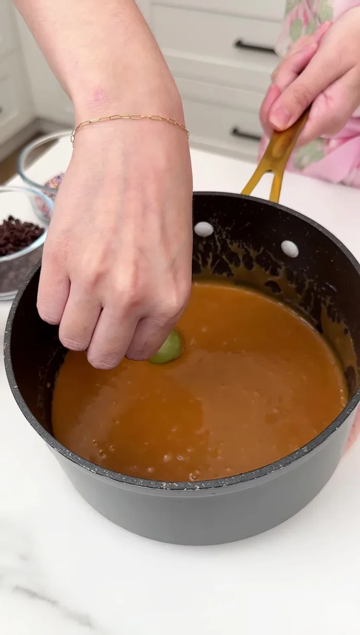 Sumergir las uvas en el caramelo derretido.