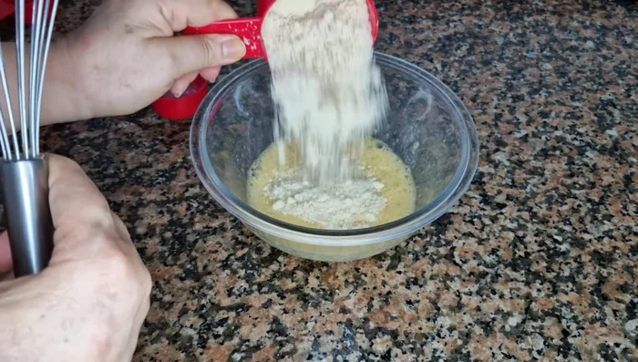 Agregar la mitad de la harina de almendras y el polvo de hornear. Mezclar.