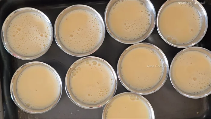Coloca los moldes en una bandeja para horno y añade agua hirviendo hasta alcanzar una altura de 2 cm.