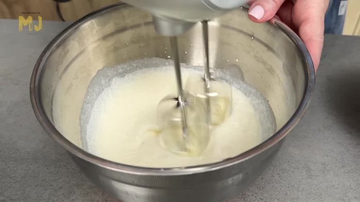 Montar 250 g de nata bien fría con una cucharada sopera de azúcar glass a velocidad alta hasta que esté firme, pero no muy dura. Reservar en la nevera.
