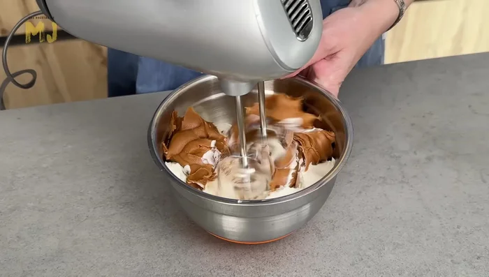 En otro bol, mezclar 400 g de queso crema con 300 g de crema de Lotus hasta integrar.