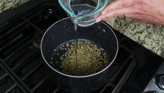 Llevar las lentejas a una cacerola con 2 tazas de agua (480ml) y hervir a fuego alto. Luego bajar el fuego a mínimo, tapar y cocinar a fuego lento durante 15-20 minutos, o hasta que estén tiernas.