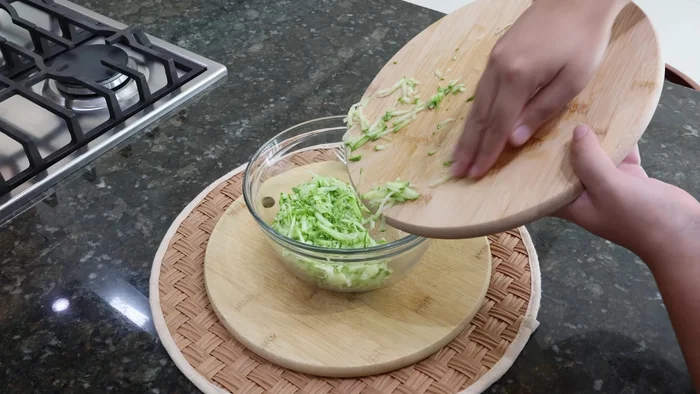 Rallar el calabacín y colocarlo en un recipiente con una cucharadita de sal. Dejar reposar 10-15 minutos.