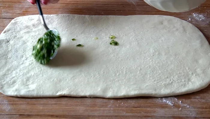 Extender la mezcla de ajo y perejil sobre la masa.