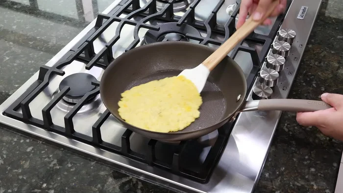 Para las quesadillas, colocar otra tortilla en la sartén caliente. Agregar queso rallado y jamón de pavo picado finamente encima.