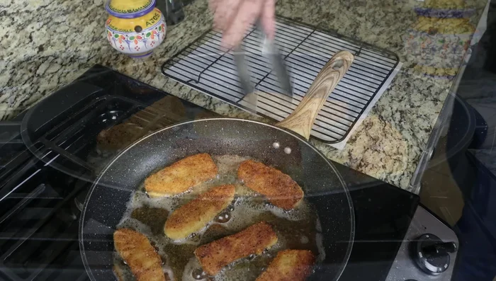 Escurrir los palitos fritos sobre una rejilla con toallas de papel.