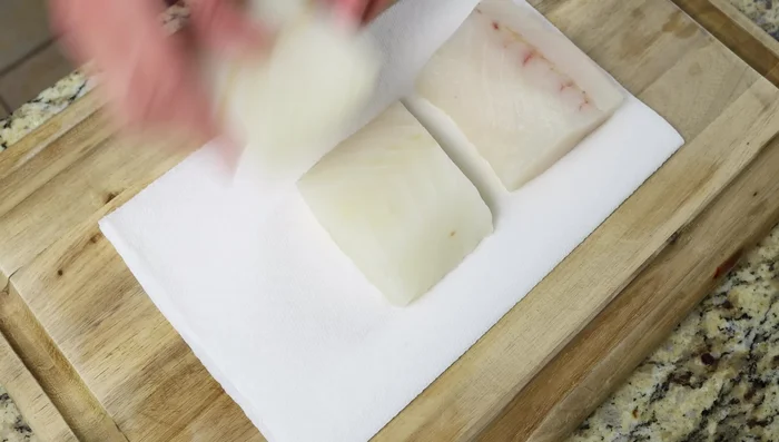 Secar completamente los filetes de bacalao con toallas de papel.