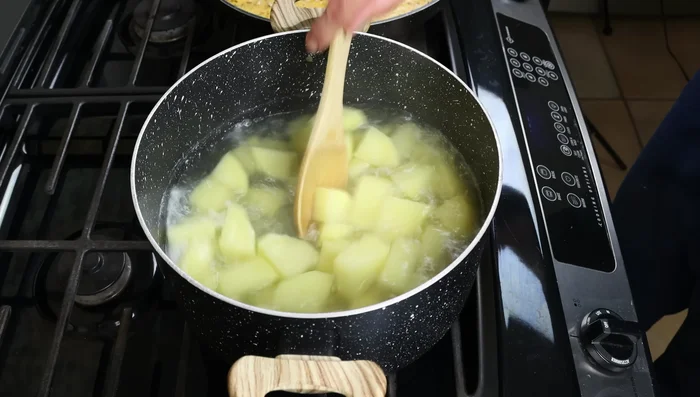 Cuando las patatas estén cocidas (15-20 minutos, comprobar con un palillo), escurrirlas y añadirlas a la sartén con la salsa.