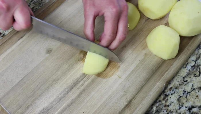 Pelar, lavar y secar las patatas. Cortarlas en trozos pequeños de 2 cm.