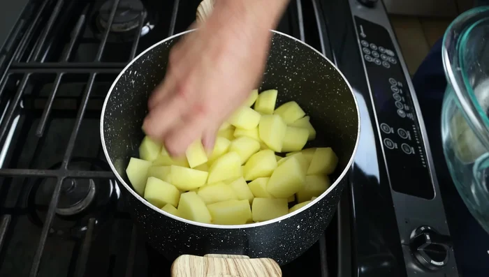 Colocar las patatas en una olla, cubrir con agua apenas hasta cubrirlas, sazonar con sal y llevar a ebullición a fuego alto.