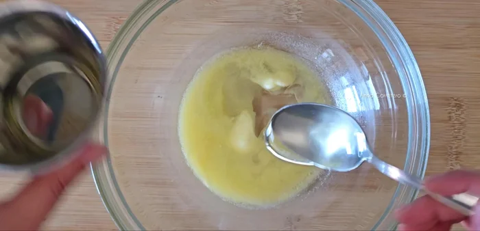 Prepara la masa mezclando la mantequilla (50g), aceite de girasol (3 cucharadas), azúcar (100g), ralladura de limón, yogur, vainilla, miel, huevos, harina (150g) y polvo de hornear.