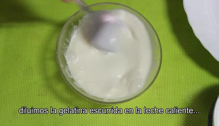 Añadir la gelatina escurrida disuelta en leche caliente a la mezcla de queso y yemas.