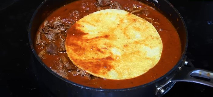 Unta tortillas de maíz con la salsa, agrega la carne deshebrada y queso. Cocina en una sartén hasta que el queso se derrita.