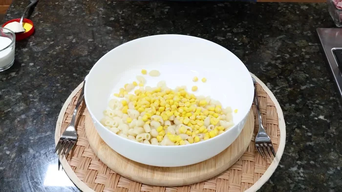 Agregar elote amarillo, zanahoria rallada, chile serrano picado, lechuga picada y jamón de pavo picado a la pasta.